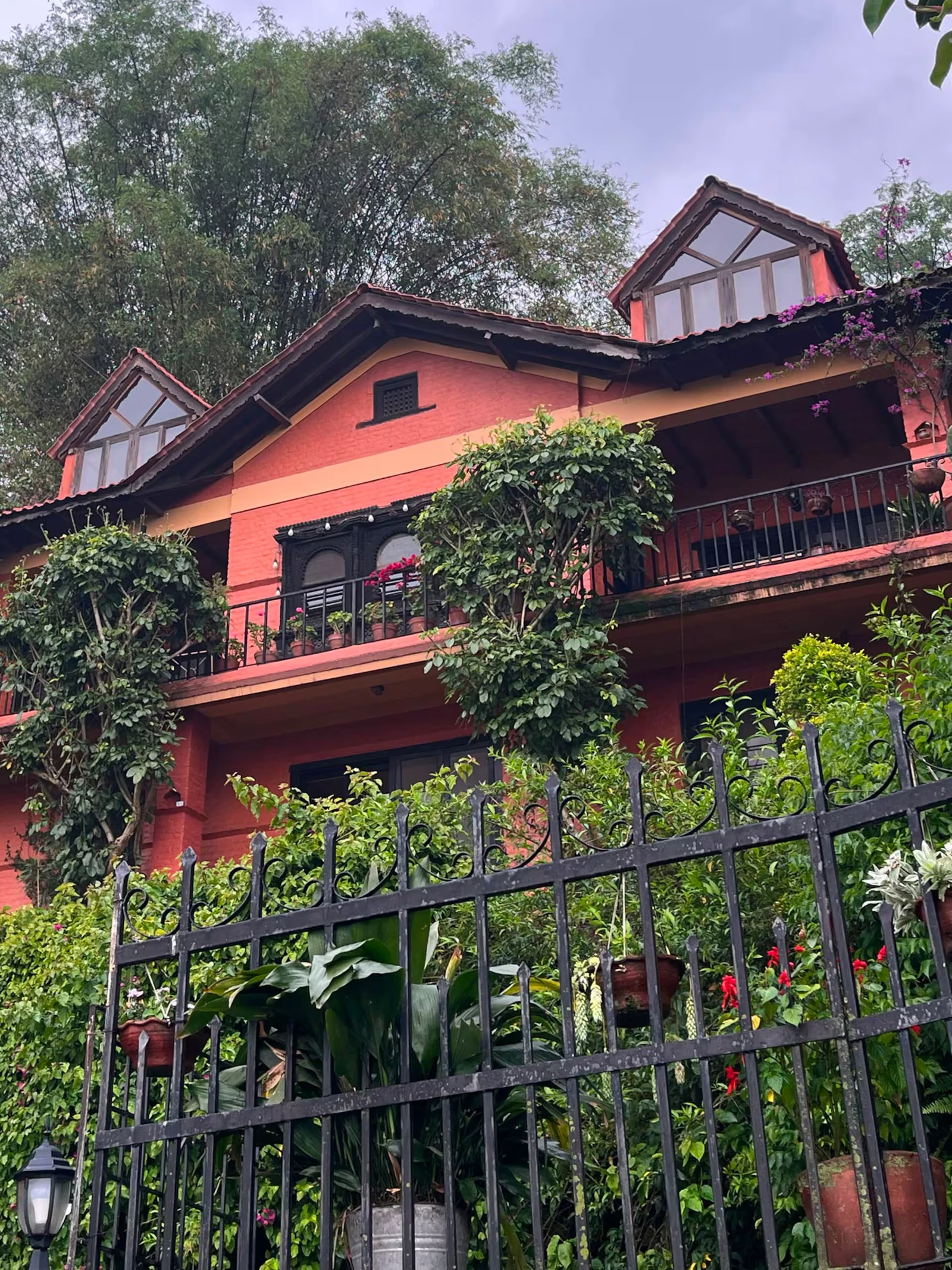 Gurje Villa red-brick facade with glass dormers behind the wrought-iron gate