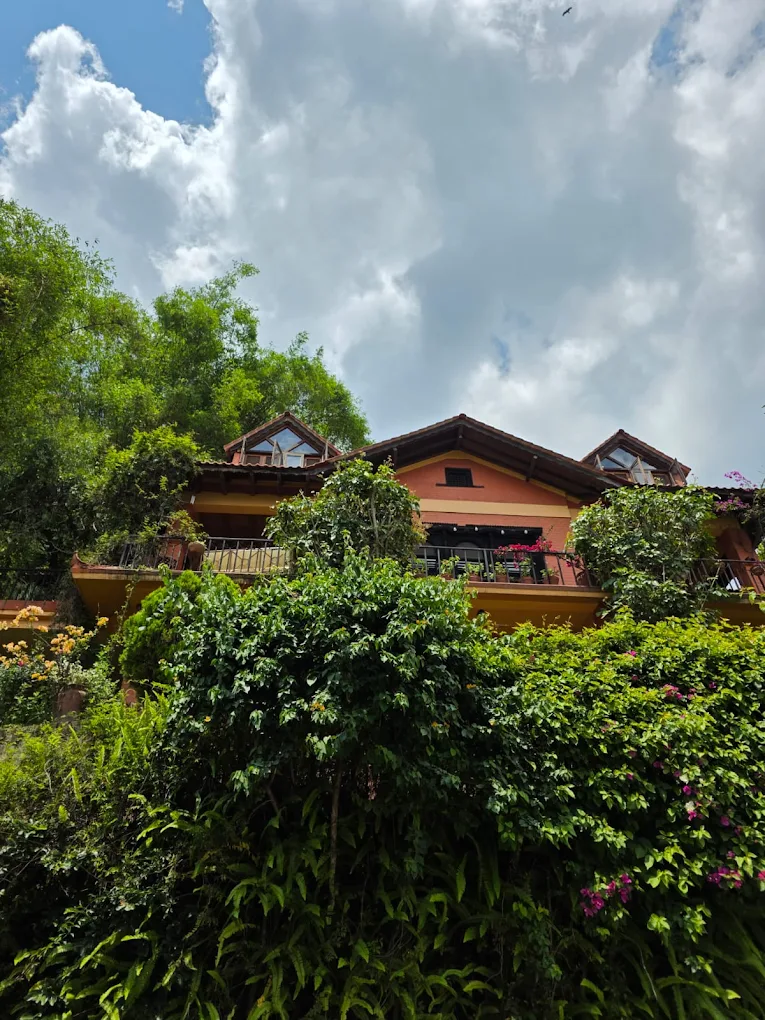 Gurje Villa balconies and dormers above lush greenery