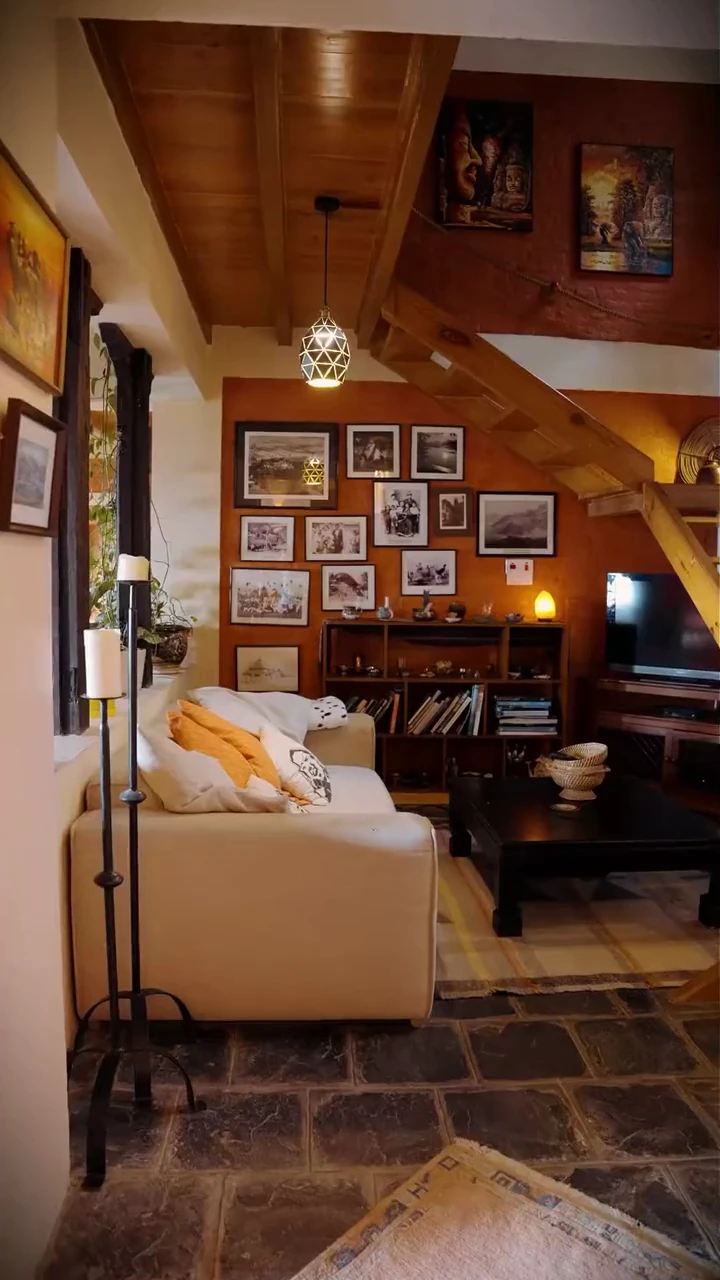 Living room with a cream sofa, framed photographs and timber staircase