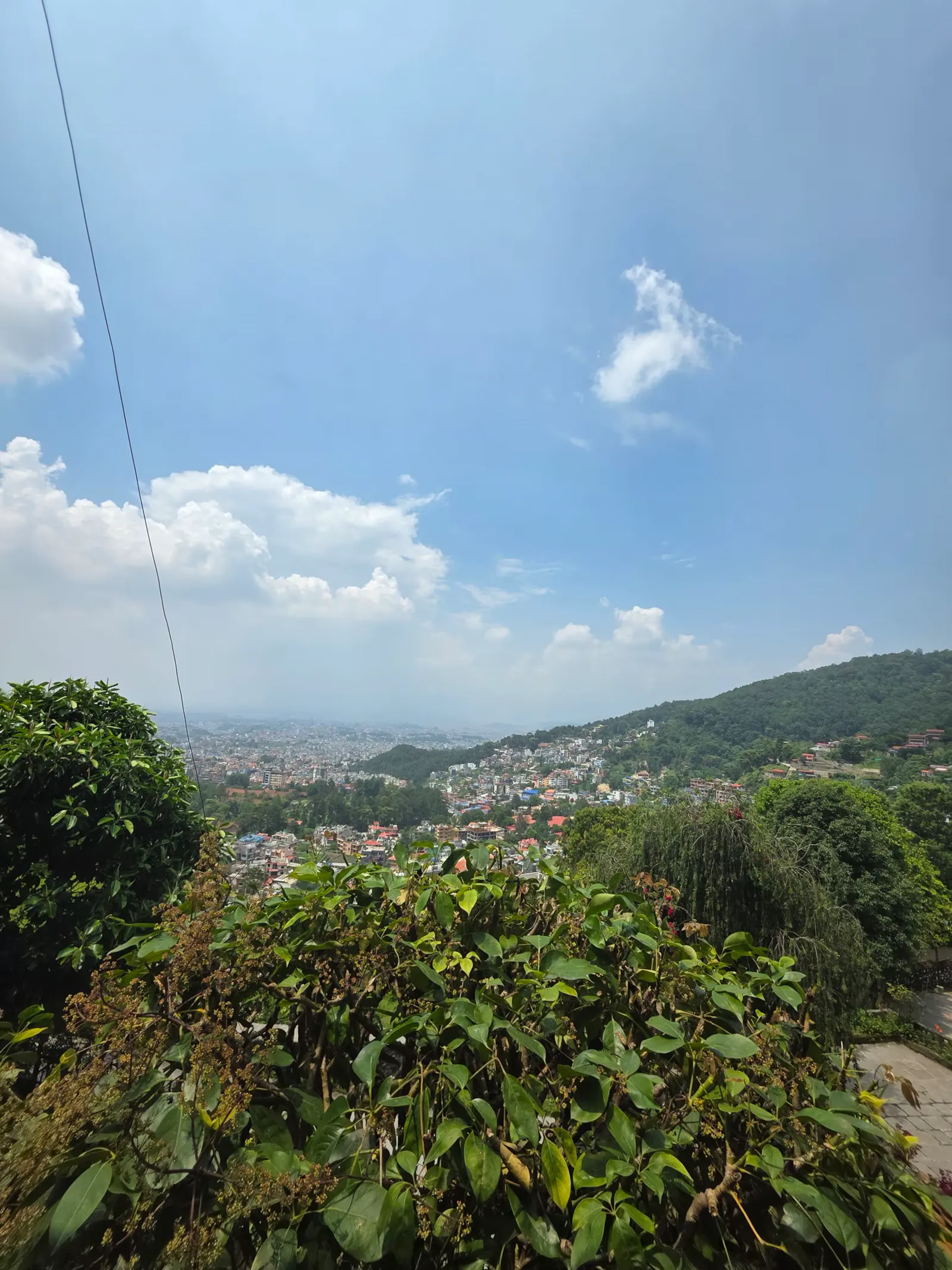 View over the treetops to the Kathmandu valley and hills